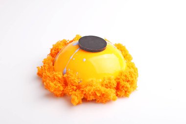 Beyaz arka plan üzerinde moleküler bisküvi ile dekore edilmiş sır ile turuncu kek.