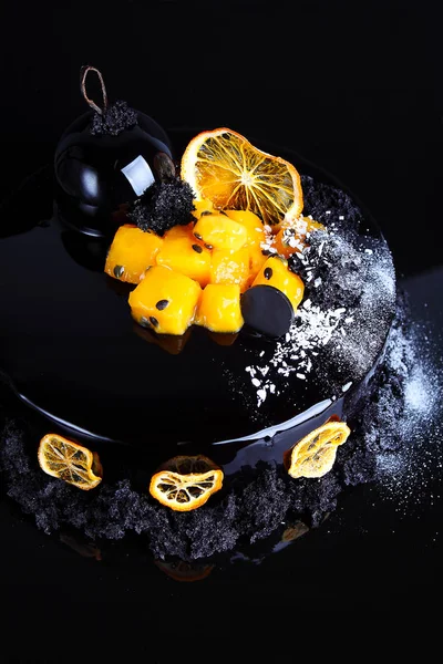 黒釉分子ビスケットと黒い背景にパッション フルーツで飾られたケーキ — ストック写真