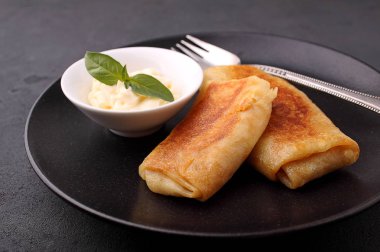 Haddelenmiş krep et ve siyah tabakta sos ile