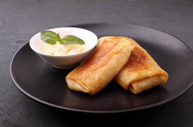 Haddelenmiş krep et ve siyah tabakta sos ile