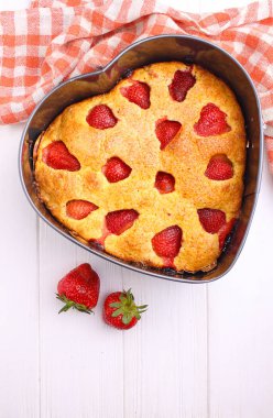 Beyaz bir arka plan üzerinde kalp şeklinde Çilekli pasta