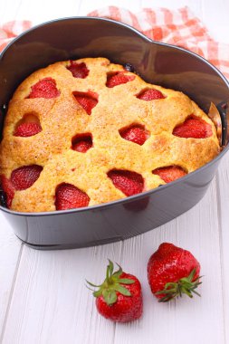 Beyaz bir arka plan üzerinde kalp şeklinde Çilekli pasta