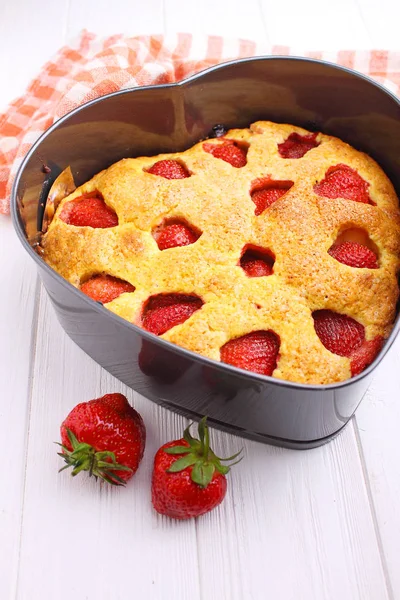 Beyaz bir arka plan üzerinde kalp şeklinde Çilekli pasta