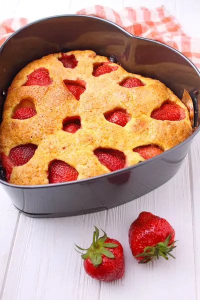 Beyaz bir arka plan üzerinde kalp şeklinde Çilekli pasta