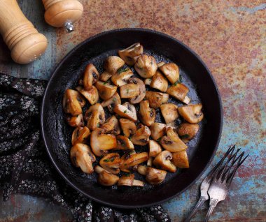 Siyah tavada kızartılmış mantarlar, kırsal arka plan, üst görünüm.