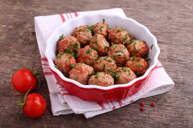 Maydanozla süslenmiş domates soslu köfteler.