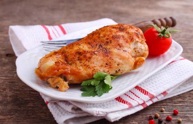 Koyu arkaplanda bir tabakta tavuk göğsü.