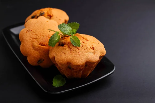 Muffin Mit Rosinen Dekoriert Mit Minzblättern Auf Schwarzem Hintergrund — Stockfoto