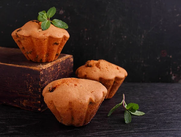 Muffin Met Rozijnen Versierd Met Muntbladeren Een Donkere Achtergrond — Stockfoto