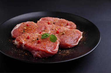 Arka planda baharatlı çiğ domuz bifteği.