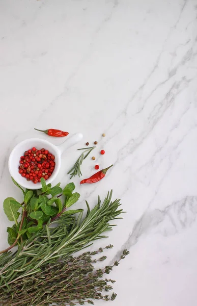 Herbs and spices: rosemary, mint, thyme, pepper on a marble background, top view. Copy space