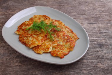 Kırsal bir zeminde dereotuyla dekore edilmiş bir tabakta patatesli gözleme.