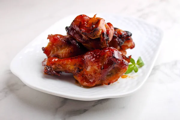 Baked chicken wings in soy sauce and honey, on a marble background