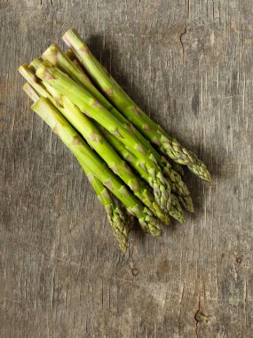 Ahşap arka planda taze kuşkonmaz bankları, üst manzara.