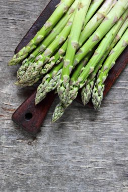 Ahşap arka planda taze kuşkonmaz bankları, üst manzara.