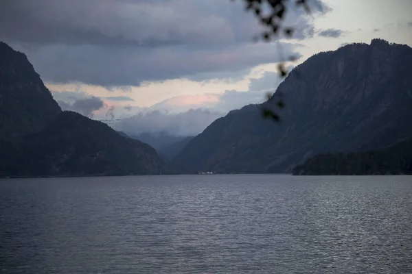 Bulutlu bir akşamda Norveç fiyordu, huş dalı yaz tatili, sakin Kuzey denizi.