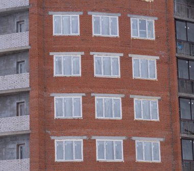 İnşaat halindeki bir evin tuğla duvarında köpüklü pencere çerçeveleri