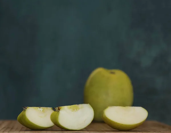 Three apple slices on the background of a whole large fruit
