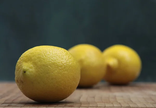 One ripe lemon on a background of two others