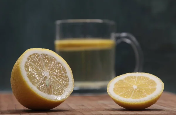 Sliced lemon on a background of a glass with green tea