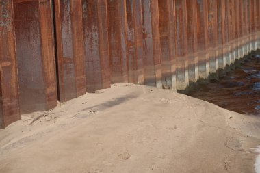 Su ve kum sınırındaki kıyıları güçlendiren çelik yığınları.