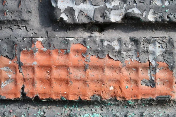 Embossed red brick with layers of peeling paint