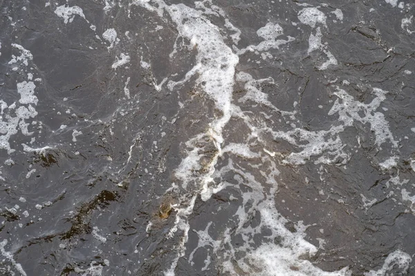 Waves and foam on the water surface