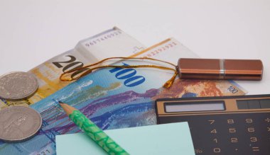 Banknotlar yüz iki yüz İsviçre frangı, defter, kalem, hesap makinesi, flaş bellek, finansal analiz