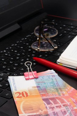 20 İsviçre frangı banknot, gözlük, defter, hesap makinesi, siyah arkaplan, metin yazarlığı, internette para kazanmak, sipariş 2 'ye makaleler yazmak
