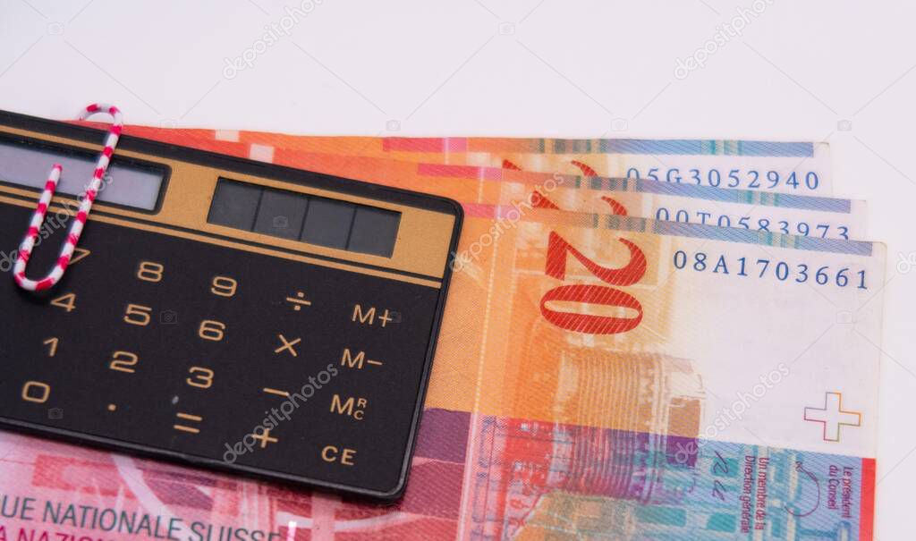 Twenty Swiss francs banknote, paper clip, calculator, financial control, planning