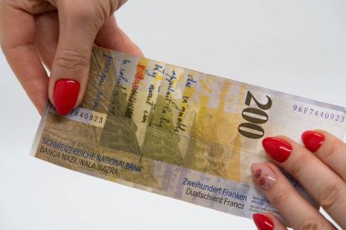 200 franklık İsviçre banknotunu tutan kadın parmakları.