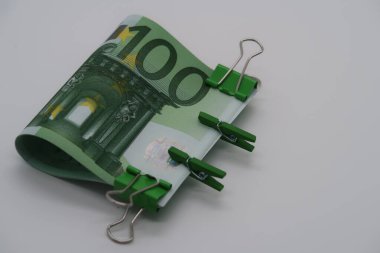 100 avroluk banknotlar, büyük ve küçük yeşil ataçlar, sıkı bir tutuş..