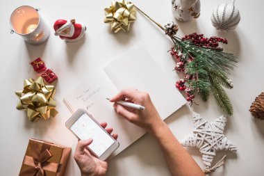 Yeni yıl kararları üstünde defter ile yeni yıl süslemeleri bir el ile yazılmış