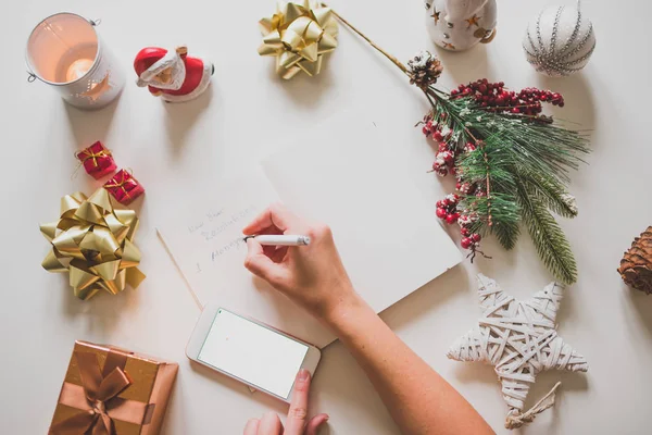 New year resolutions written with a hand on notebook with new years decorations — Stock Photo, Image