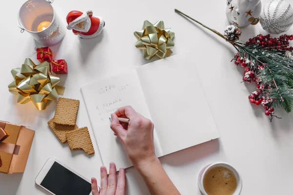 "Lista de regalos "escrito con una mano en el cuaderno con la decoración de año nuevo — Foto de Stock