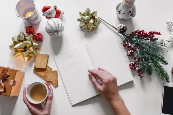 "Present lista "skriven med en hand på anteckningsbok med nyår dekor — Stockfoto