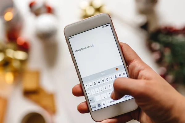 Hand holding a smartphone and writting Merry Christmas — Stock Photo, Image