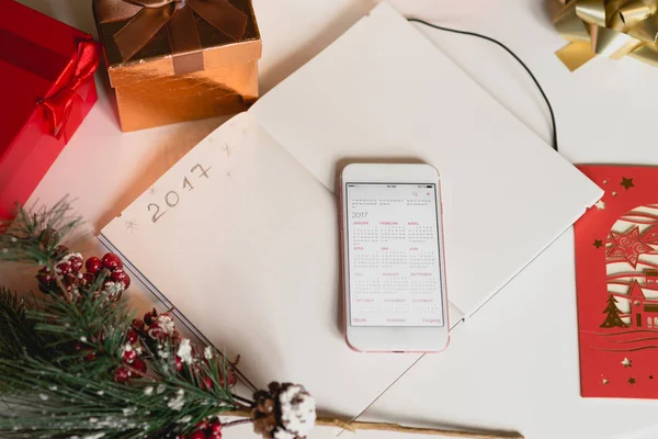 2017 written on notebook with new years decorations and mobile pone — Stock Photo, Image