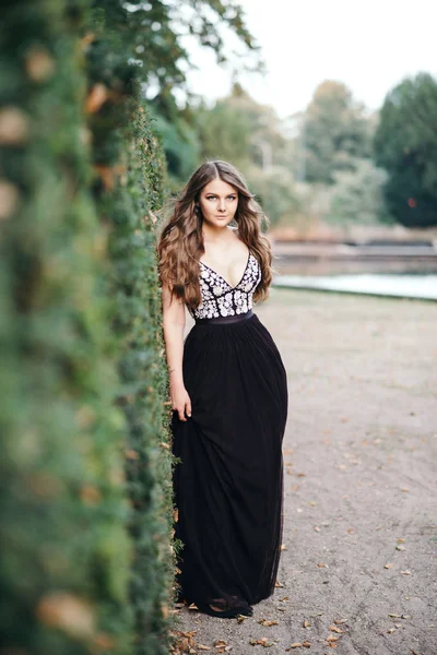 Giovane bella donna in abito da sera lungo nero in piedi — Foto Stock