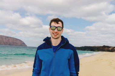 Sahilde bardaklarda yakışıklı adam