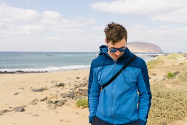 Sahilde bardaklarda yakışıklı adam