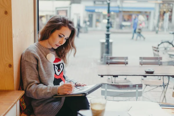 Vacker flicka Rita med penna i café — Stockfoto