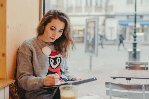 Vacker flicka Rita med penna i café — Stockfoto