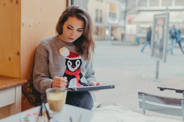 Schönes Mädchen zeichnet mit Bleistift im Café — Stockfoto