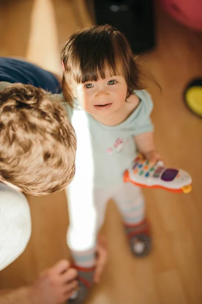Папа помогает своей маленькой дочери надеть ботинки — стоковое фото
