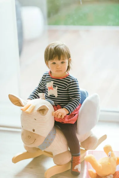 Girl swinging on a rocking horse — Stock Photo, Image