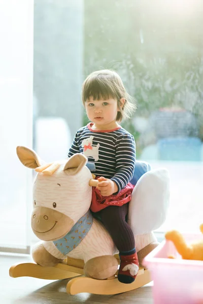 Girl swinging on a rocking horse — Stock Photo, Image