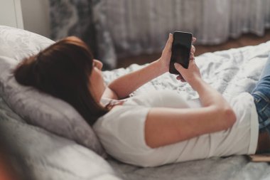 güzel bir kadın beyaz tshirt akıllı sms yazıyor 