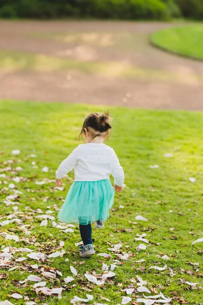 Милая малышка в парке убегает — стоковое фото