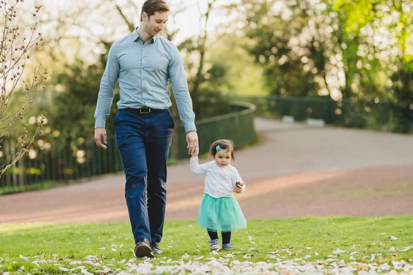 Niña en el parque con el padre en el fondo —  Fotos de Stock